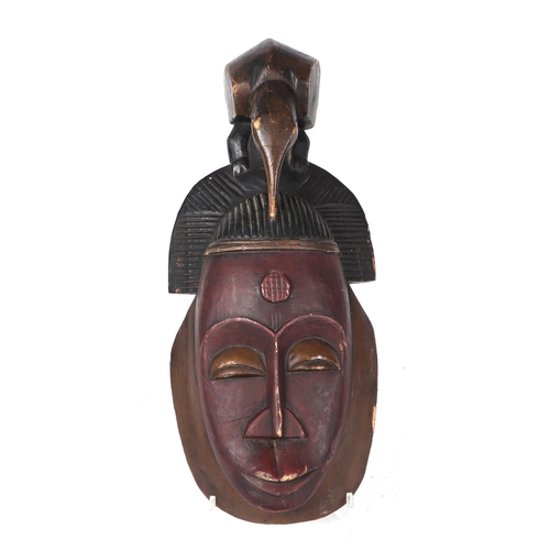 261 - An African carved wooden wall mask, 48cms high.