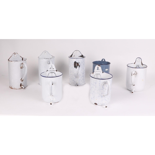 316 - A large quantity of vintage enamelware to include measures, water jug and ladle rack.