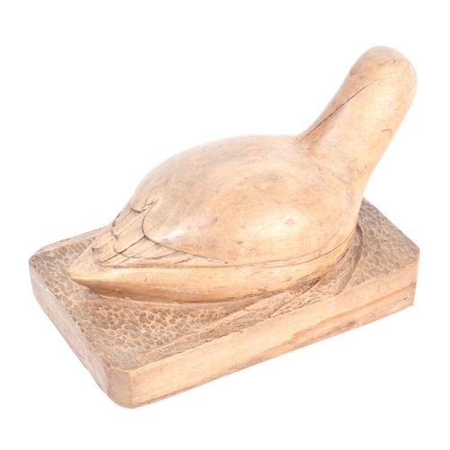 336 - Folk Art:  A wooden carving of a duck resting on a plinth.