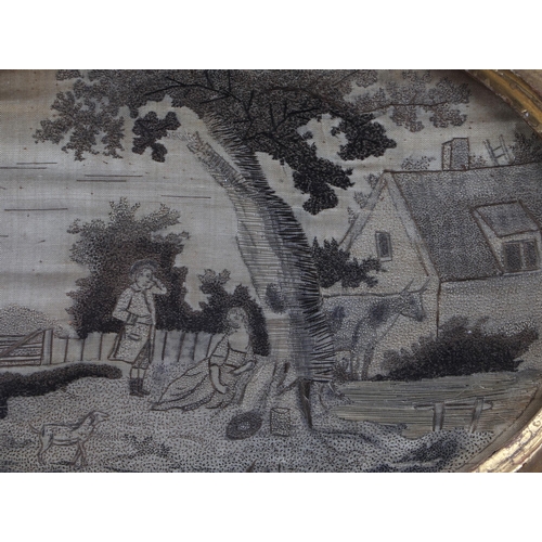 34 - An 18th century English oval silkwork embroidered panel depicting a landscape with a couple beneath ... 