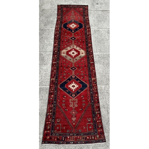 36 - A Persian hand knotted Hamadan runner of geometric design with three central medallions and stylised... 