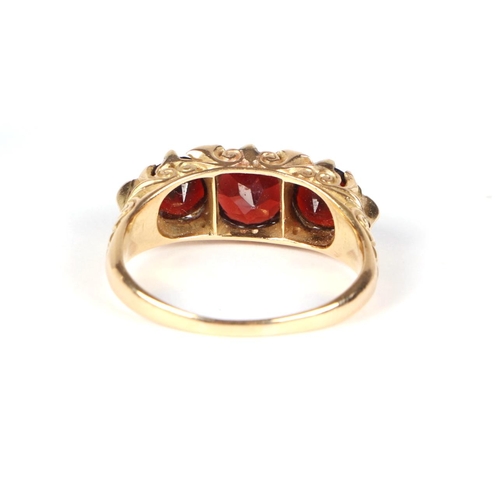 434 - An Edwardian yellow metal three-stone garnet ring interspersed with small diamonds approx UK size P,... 