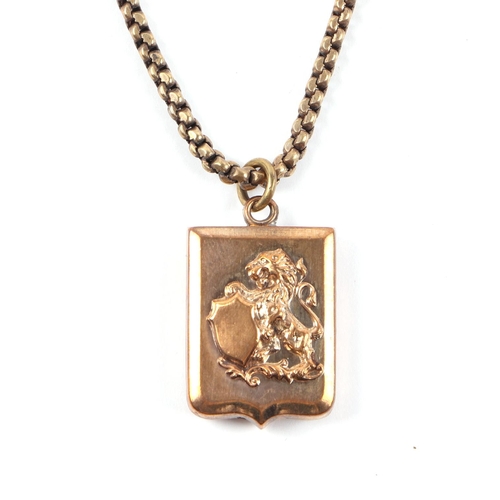 457 - A yellow metal chain with 9ct gold clasp with a shield shaped pendant bearing a family crest, chain ... 