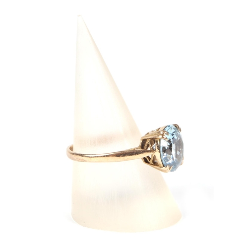 458 - A 9ct gold ring set with a large circular pale blue stone, approx UK size M, 2.7g.