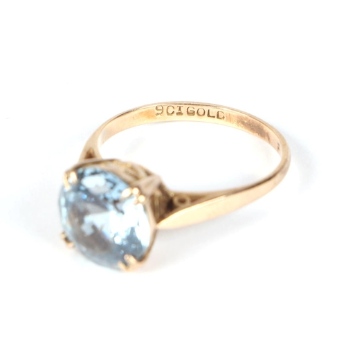 458 - A 9ct gold ring set with a large circular pale blue stone, approx UK size M, 2.7g.