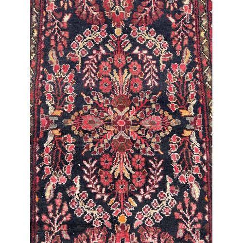 48 - A Persian hand knotted Arak runner with stylised floral design within floral guard borders, on a nav... 