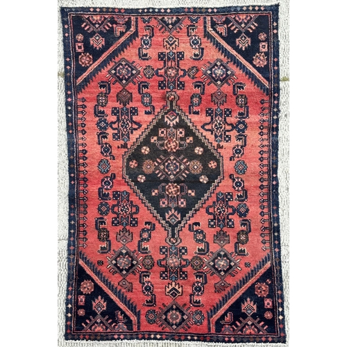 49 - A Persian hand knotted Hamadan rug with central diamond motif and blue spandrels, on a red ground, 1... 