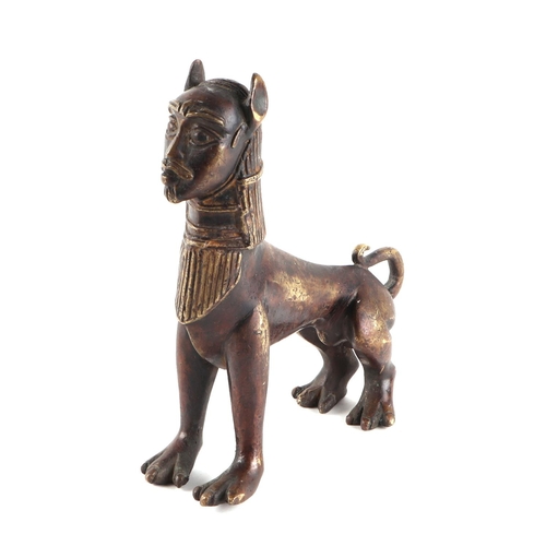 495 - An Egyptian bronze figure depicting a sphinx with stylised human head on a lions body, 17cms long.