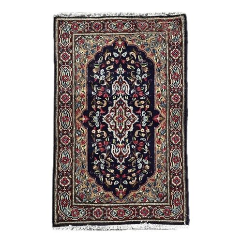 50 - A Persian Kirman hand knotted woollen rug with floral decorated central medallion, on a blue ground,... 