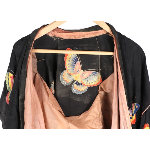 511 - A Japanese silk robe decorated with butterflies on a black ground.(a/f)