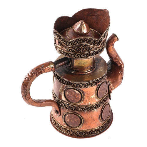 517 - A Tibetan coper teapot decorated with inset coins, 15cms high.