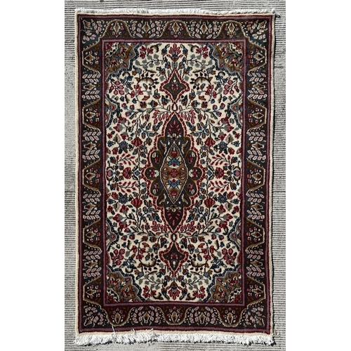 53 - A Persian Kerman rug with stylised floral design and central medallion with repeating foliate border... 