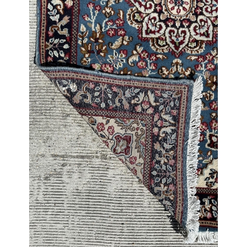 54 - A Persian Kerman hand knotted woollen rug, the central floral medallion surrounded by small sprays w... 