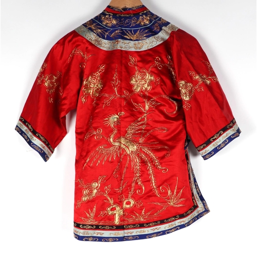 541 - A Chinese silk short jacket decorated with embroidered bullion wire phoenix and flowers, on a red gr... 