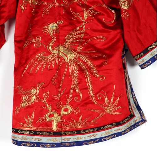 541 - A Chinese silk short jacket decorated with embroidered bullion wire phoenix and flowers, on a red gr... 