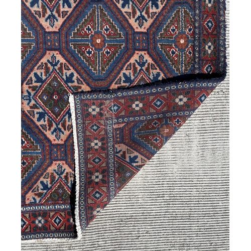 55 - A Persian Sirjan carpet with repeating blue and ivory lozenge design within a narrow repeating borde... 