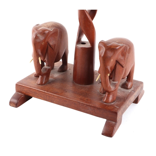 550 - An African hardwood table lamp with central open spiral column flanked by two elephants, 56cms high ... 