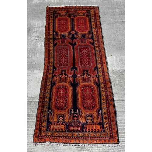 57 - A Persian hand knotted woollen Azari runner with repeating geometric medallions within repeating bor... 