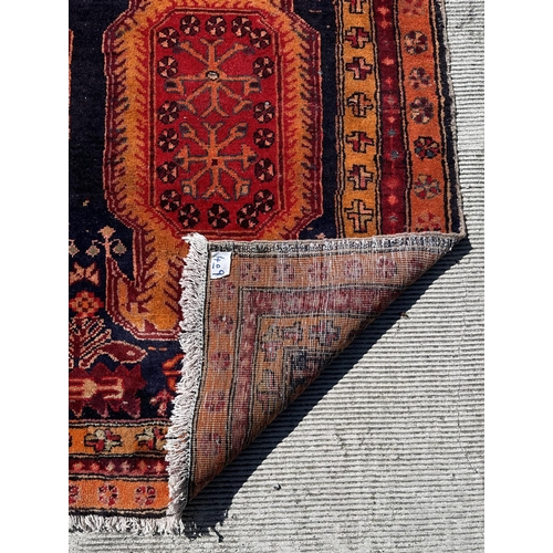 57 - A Persian hand knotted woollen Azari runner with repeating geometric medallions within repeating bor... 