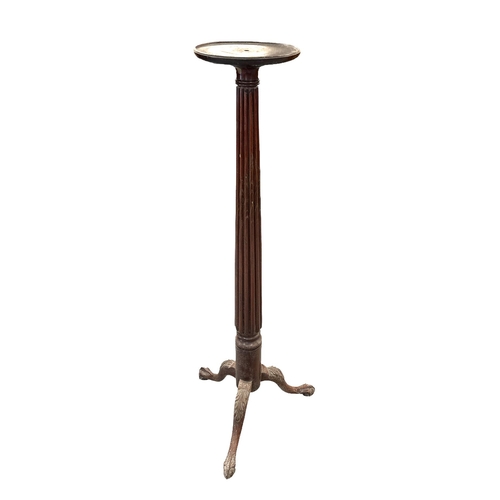 576 - A Victorian mahogany torchere with tapering reeded column and carved acanthus leaf capped tripod bas... 