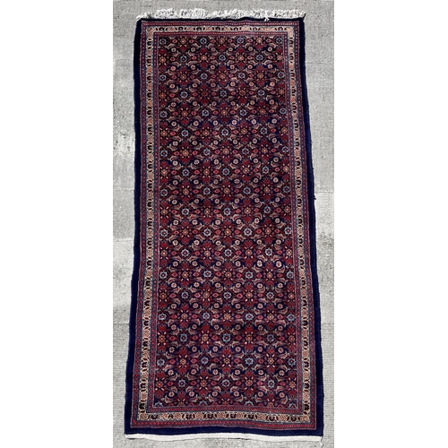 59 - A Persian Sarouk runner with repeating floral Herati design, on a blue ground, 300 by 120cms.