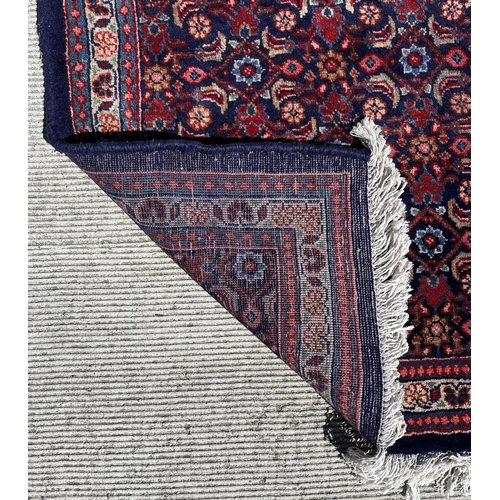 59 - A Persian Sarouk runner with repeating floral Herati design, on a blue ground, 300 by 120cms.