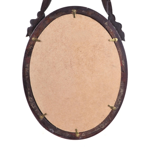 620 - A gilt framed oval mirror with ribbon bow decoration, overall 23 by 53cms.