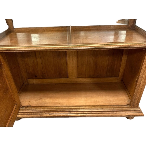 631 - A continental oak buffet, the arched mirrored back above a glazed section with sliding doors and lar... 