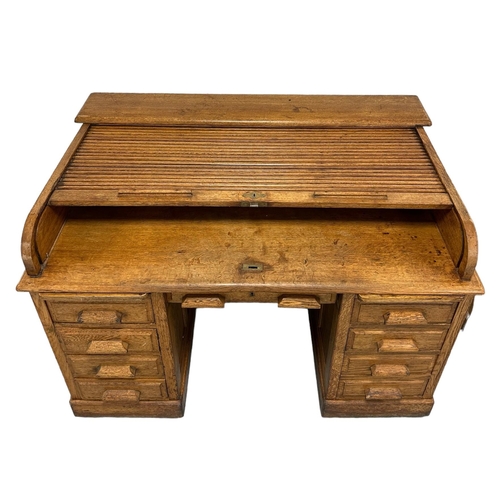 642 - An early 20th century Kenryck & Jefferson Ltd oak roll-top desk, the tambour roll-top above an arran... 