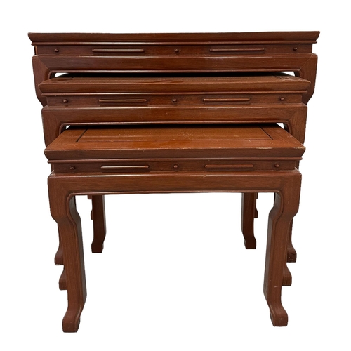 656 - A nest of three Chinese hardwood tables, the largest 61cms wide.