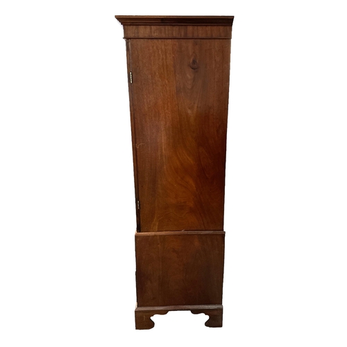 664 - A 19th century mahogany wardrobe, the pair of panelled doors enclosing a hanging rail above two shor... 