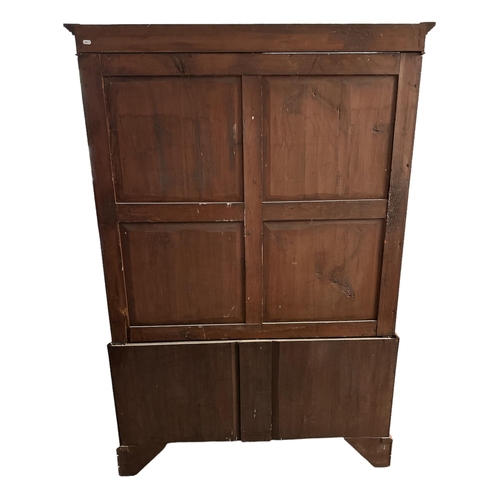 664 - A 19th century mahogany wardrobe, the pair of panelled doors enclosing a hanging rail above two shor... 