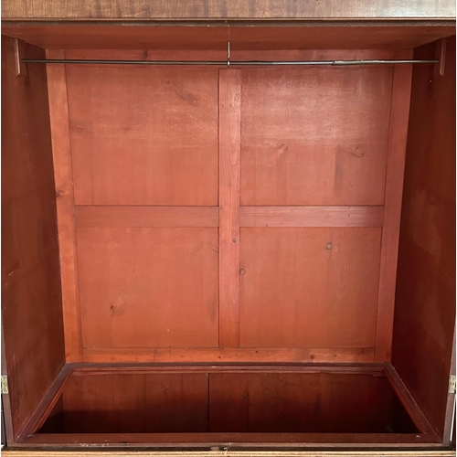 664 - A 19th century mahogany wardrobe, the pair of panelled doors enclosing a hanging rail above two shor... 