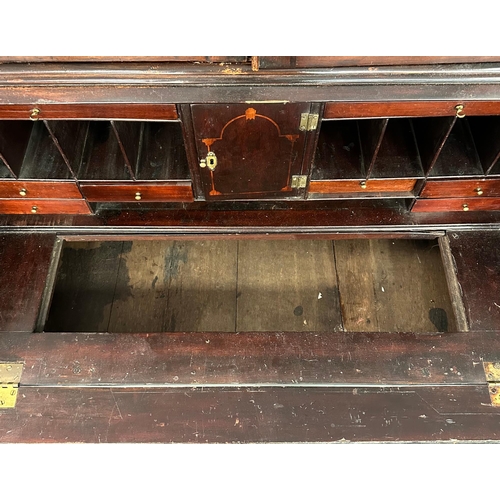 667 - An early 19th century mahogany bureau bookcase, the pair of shaped glazed doors enclosing a shelved ... 