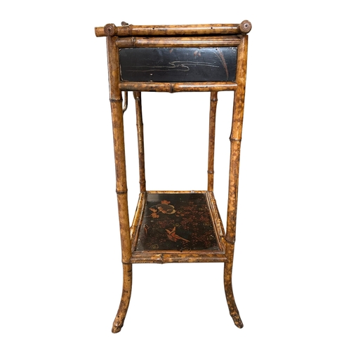 669 - A late 19th century Aesthetic period bamboo work table with lacquer panels, 45cms wide.