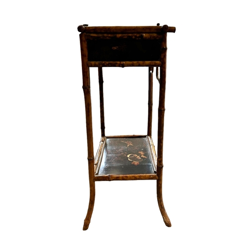 669 - A late 19th century Aesthetic period bamboo work table with lacquer panels, 45cms wide.