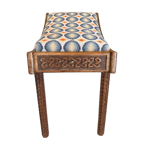 671 - An Arts & Crafts carved walnut stool with upholstered seat, the frieze carved with Celtic scrolls, 6... 