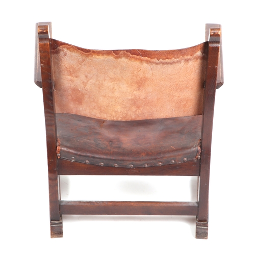 750 - An Arts & Crafts inspired stained beech child's armchair with leather back and seat.