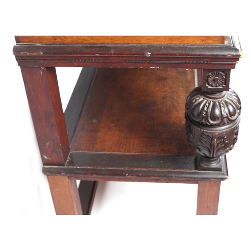 594 - An oak two-tier side table with carved supports, 90cms wide.