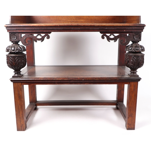 594 - An oak two-tier side table with carved supports, 90cms wide.