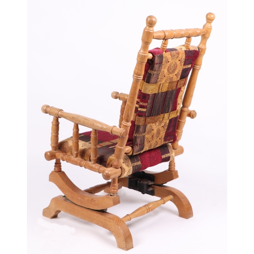 614 - A child's American rocking chair with upholstered seat and back.