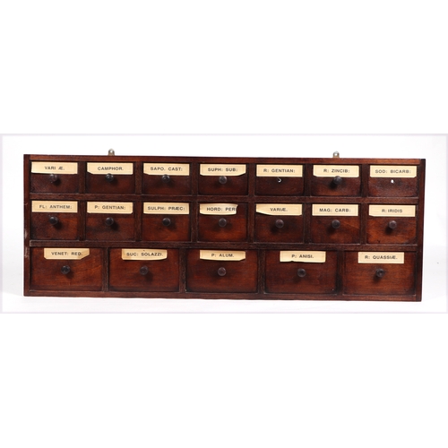 355A - A decorative wall plaque constructed from apothecary drawer fronts, 122.5cms wide.