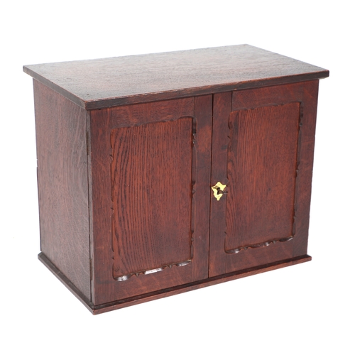 573 - A late 19th / early 20th century oak table top cupboard, the pair of doors enclosing pigeon holes, 4... 