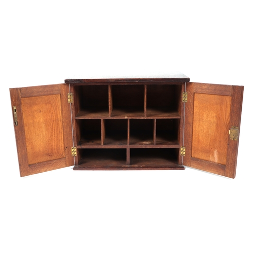 573 - A late 19th / early 20th century oak table top cupboard, the pair of doors enclosing pigeon holes, 4... 