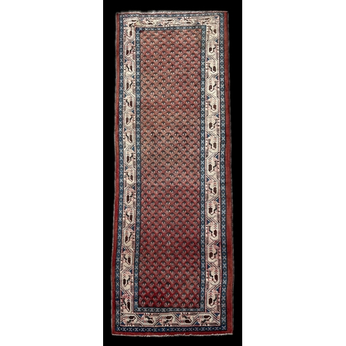 58 - A Persian Hamadan runner with repeating floral boteh on a red ground with blue and ivory borders, 33... 