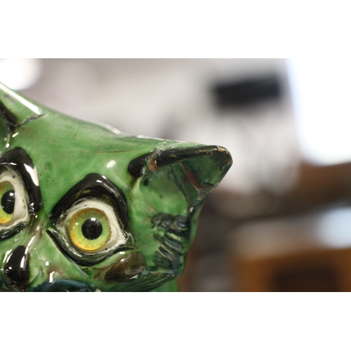 243 - A C H Brannam Art pottery cat with glass eyes, 33cms high (a/f).