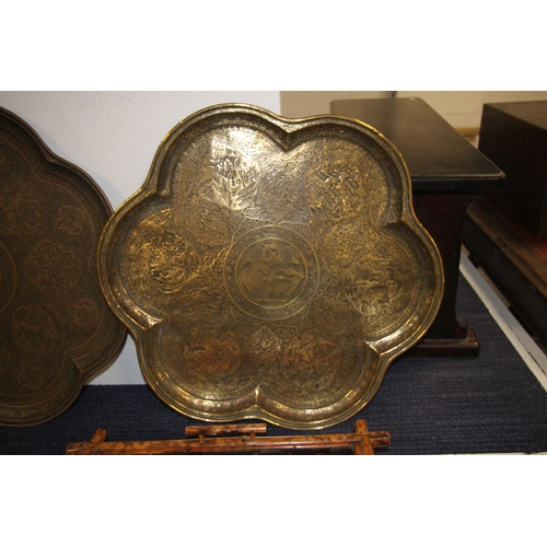 501 - A Persian brass tray of shaped form decorated with figures within panels and foliate scrolls, 57cms ... 