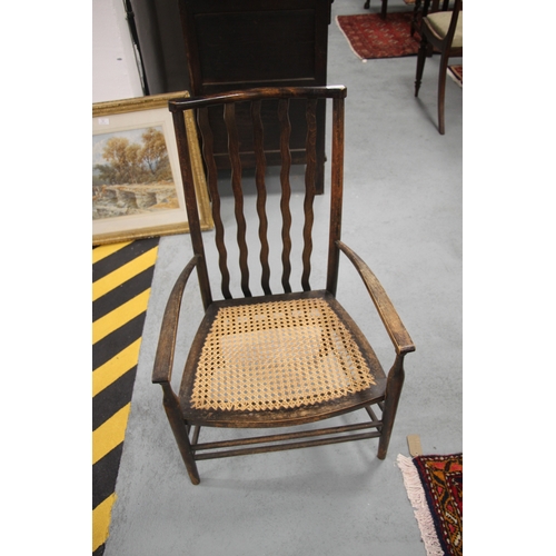 654 - An early 20th century ebonised Arts & Crafts armchair in the style of Morris & Co. with five wavy sl... 