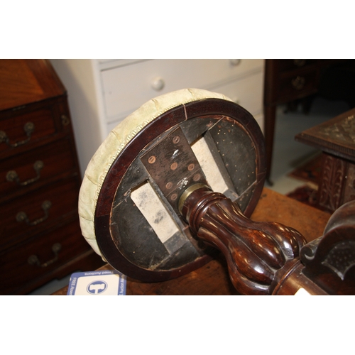 705 - A Victorian carved walnut adjustable piano stool on a tripod base with carved acanthus leaf decorati... 