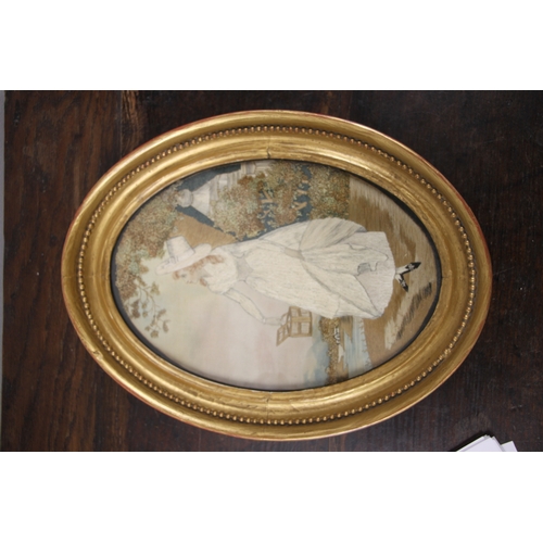 33 - A 19th century silk needlework oval panel depicting a young lady with white dress and bonnet holding... 